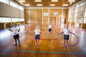 Students playing with hula hoop in school gym