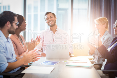 Coworkers applauding a colleague after presentation