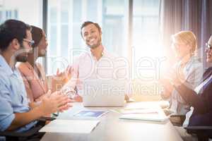 Coworkers applauding a colleague after presentation