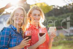 Beautiful women holding glasses of red wine and mobile phone