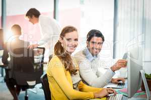 Portrait of executives working on laptop and computer