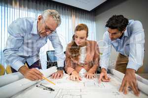 Businesswoman and coworkers discussing blueprint