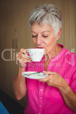 Portrait of a smiling woman drinking a tea