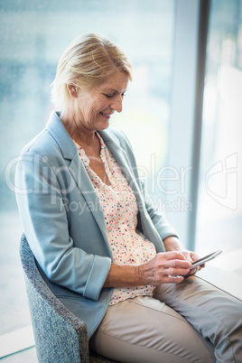 Businesswoman text messaging on mobile phone