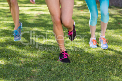 Female athlete feet running on grass
