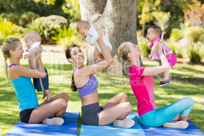 Women holding their babies while exercising