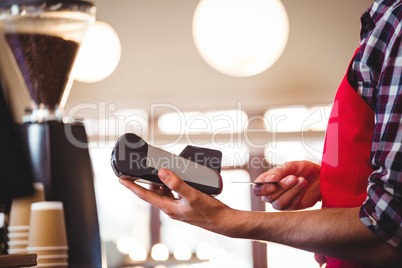 Waiter inserting customer's credit card into credit card machine