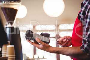 Waiter inserting customer's credit card into credit card machine