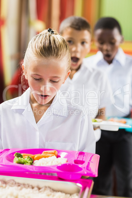 Shocked schoolgirl looking at food