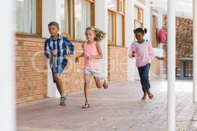 Smiling school kids running in corridor