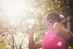 Low angle view of sporty woman drinking water