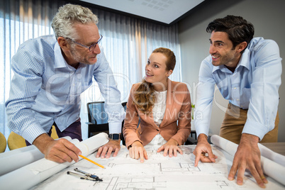 Businesswoman and coworkers discussing blueprint