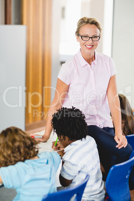 Teacher helping kids with their homework in classroom