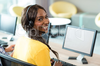 Young woman working on computer with headset