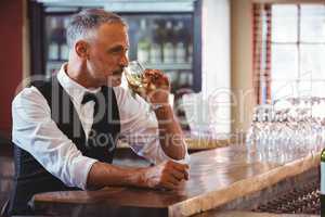 Bartender drinking wine at bar counter