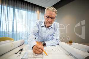 Architect working on blueprint at desk