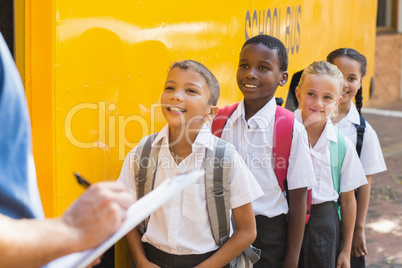 Teacher updating check list of kids