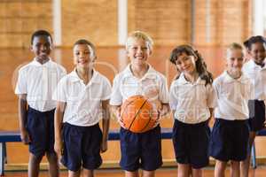 Smiling students standing with basketball