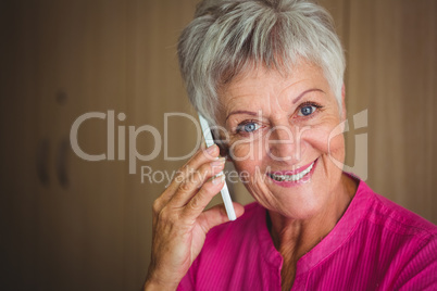 Portrait of a smiling retired woman making a call