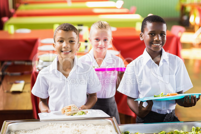 Student holding food tray in school cafeteria