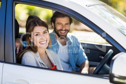 Happy couple sitting in a car