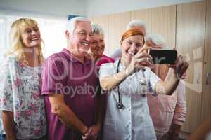 Retired people taking a selfie with a nurse