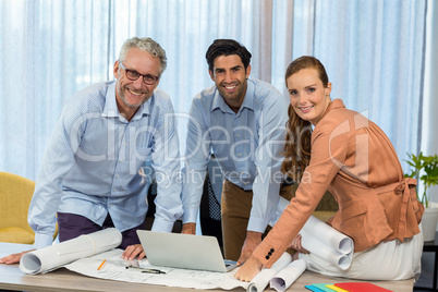 Businesswoman and coworker with blueprint on the desk