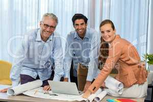 Businesswoman and coworker with blueprint on the desk