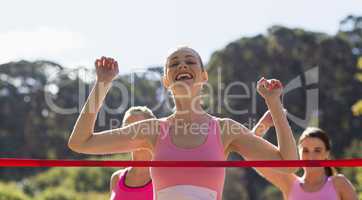 Cheerful winner athlete crossing finish line