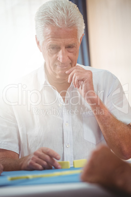 Portrait of senior man playing domino