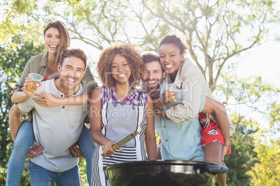 Group of friends holding a glasses of beer in park