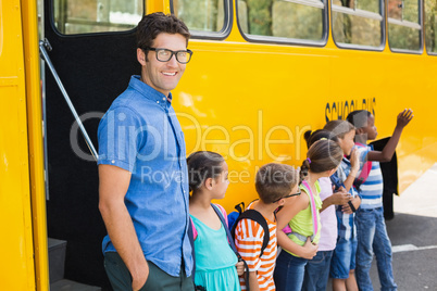 Smiling teacher and kids standing together