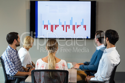 Business people discussing over graph during a meeting