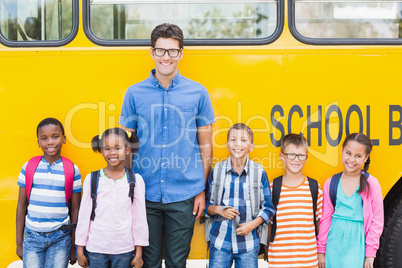 Portrait of smiling teacher and kids standing together