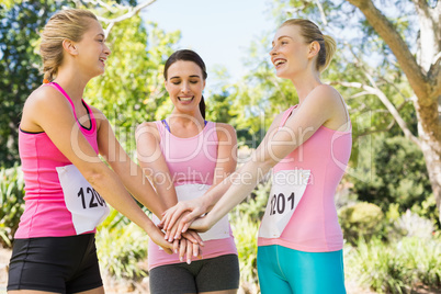 Young athlete women forming hands stack