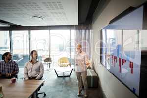 Business people discussing over graph during a meeting