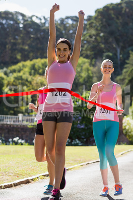 Cheerful winner athlete crossing finish line