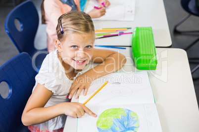 Portrait of schoolgirl studying in classroom