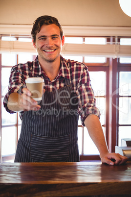 Portrait of waiter offering a cup of coffee