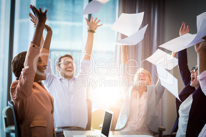 Business people throwing papers in the air