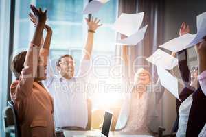 Business people throwing papers in the air