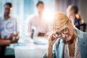 Frustrated businesswoman sitting with hand on head