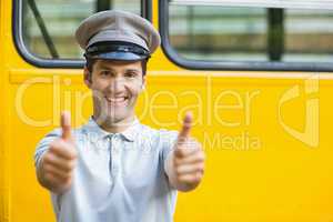 Smiling bus driver showing thumbs up in front of bus