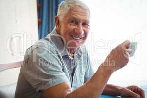 Retired smiling man holding a cup of tea