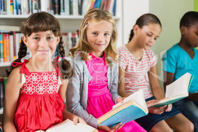 Kids reading a book in library