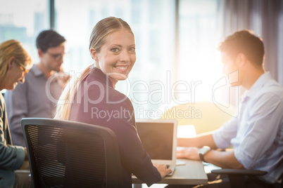 Businesswoman using laptop during meeting