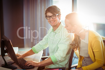 Man working on computer with coworker