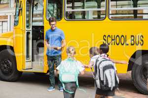 Teacher updating check list of kids while entering in bus