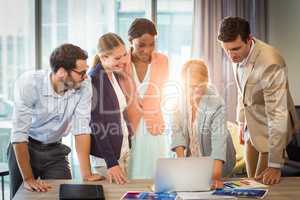 Group of business people interacting using laptop