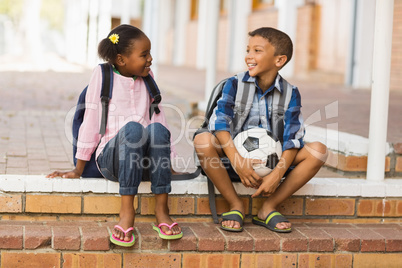 Smiling kids sitting on stairs at school